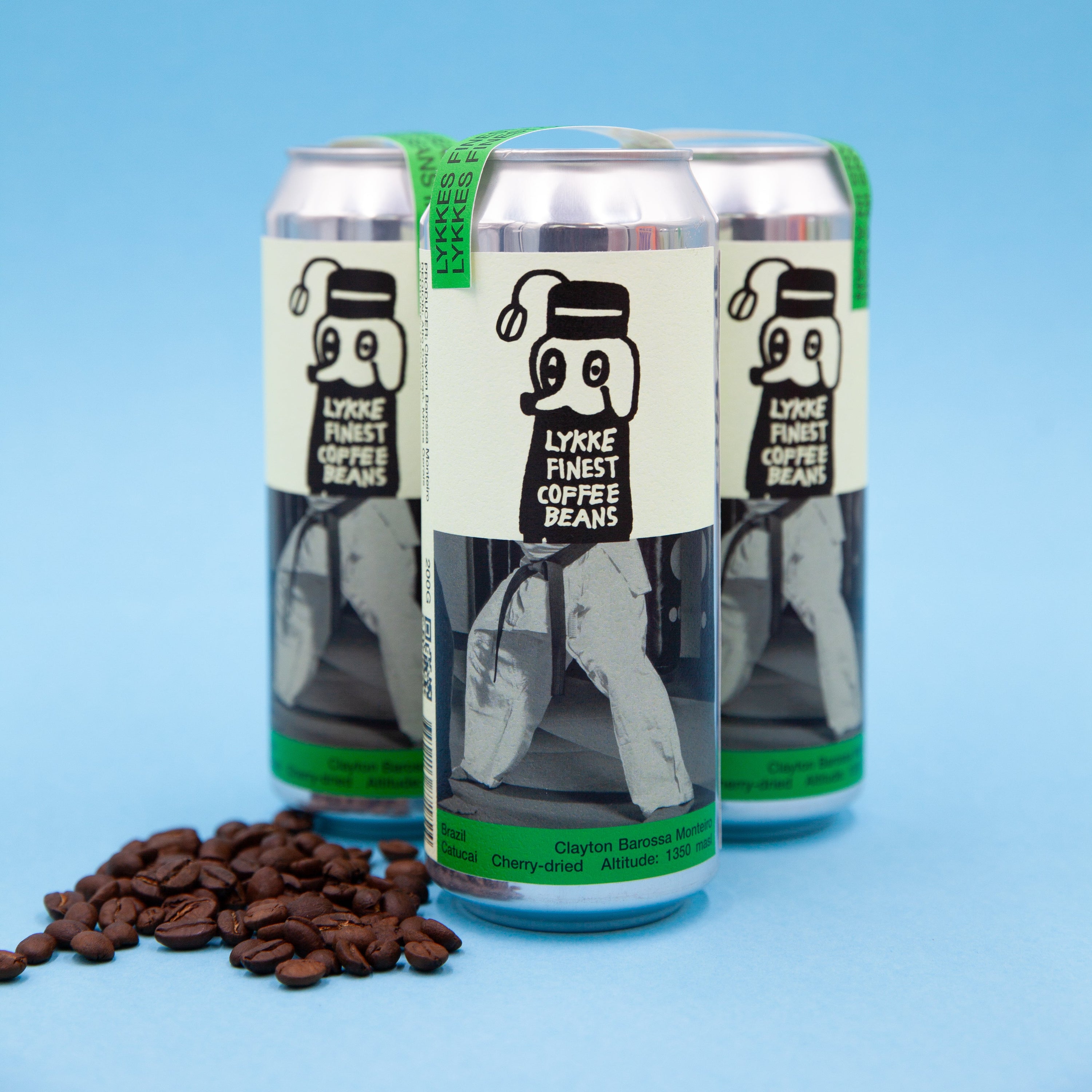 Three cans of Lykke Coffee Beans on a blue background with coffee beans in front.
